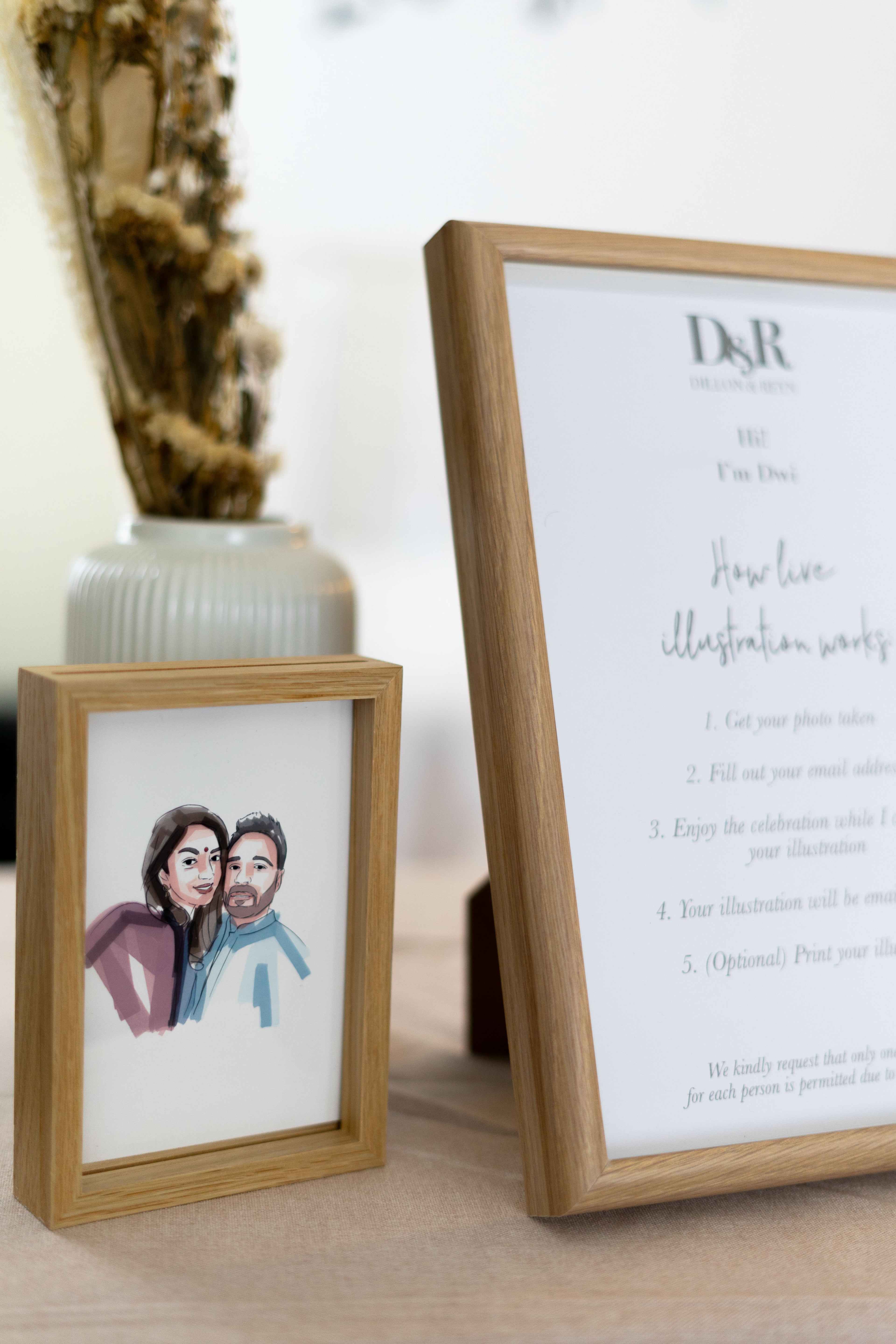 Framed live guest couple illustration display on table